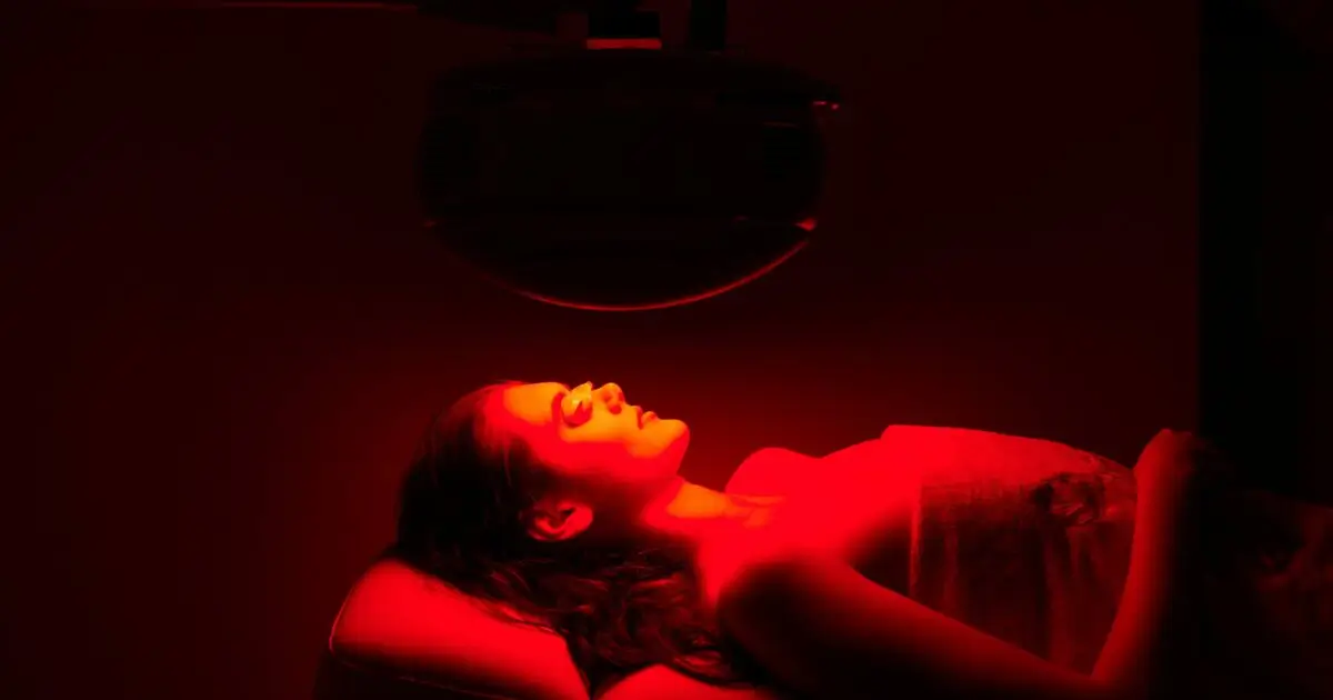 Person sleeping under gentle red light therapy for deep sleep enhancement